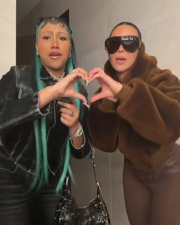 Kim Kardashian and North West making a heart shape with their hands 