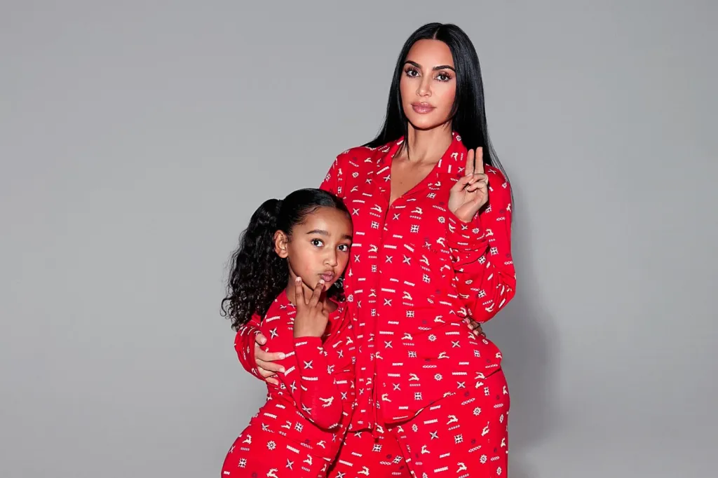 Kim Kardashian and her daughter Chicago posing in red Christmas pajamas.