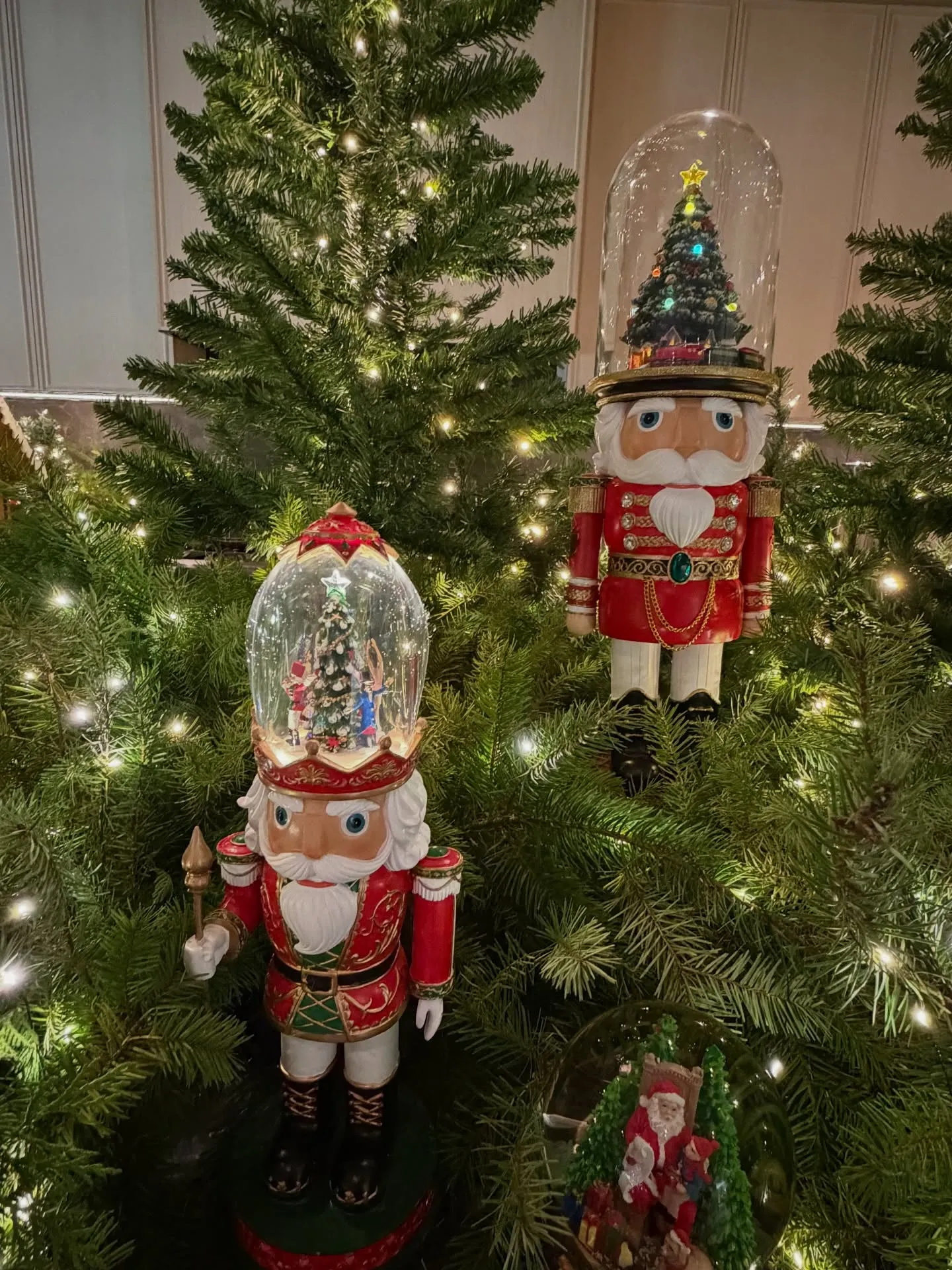 Three nutcracker decorations among Christmas trees.