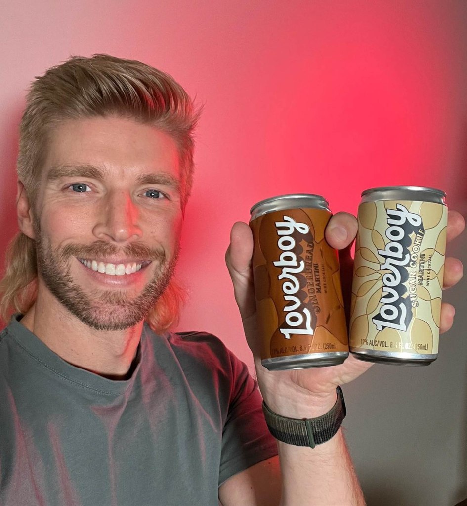 Kyle Cooke holding cans of Loverboy Gingerbread Martini and Sugar Cookie Martini.
