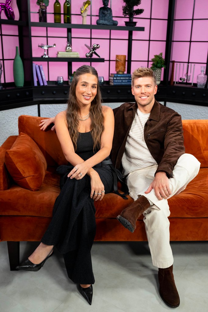 Kyle Cooke and Amanda Batula from Summer House, sitting on an orange couch.