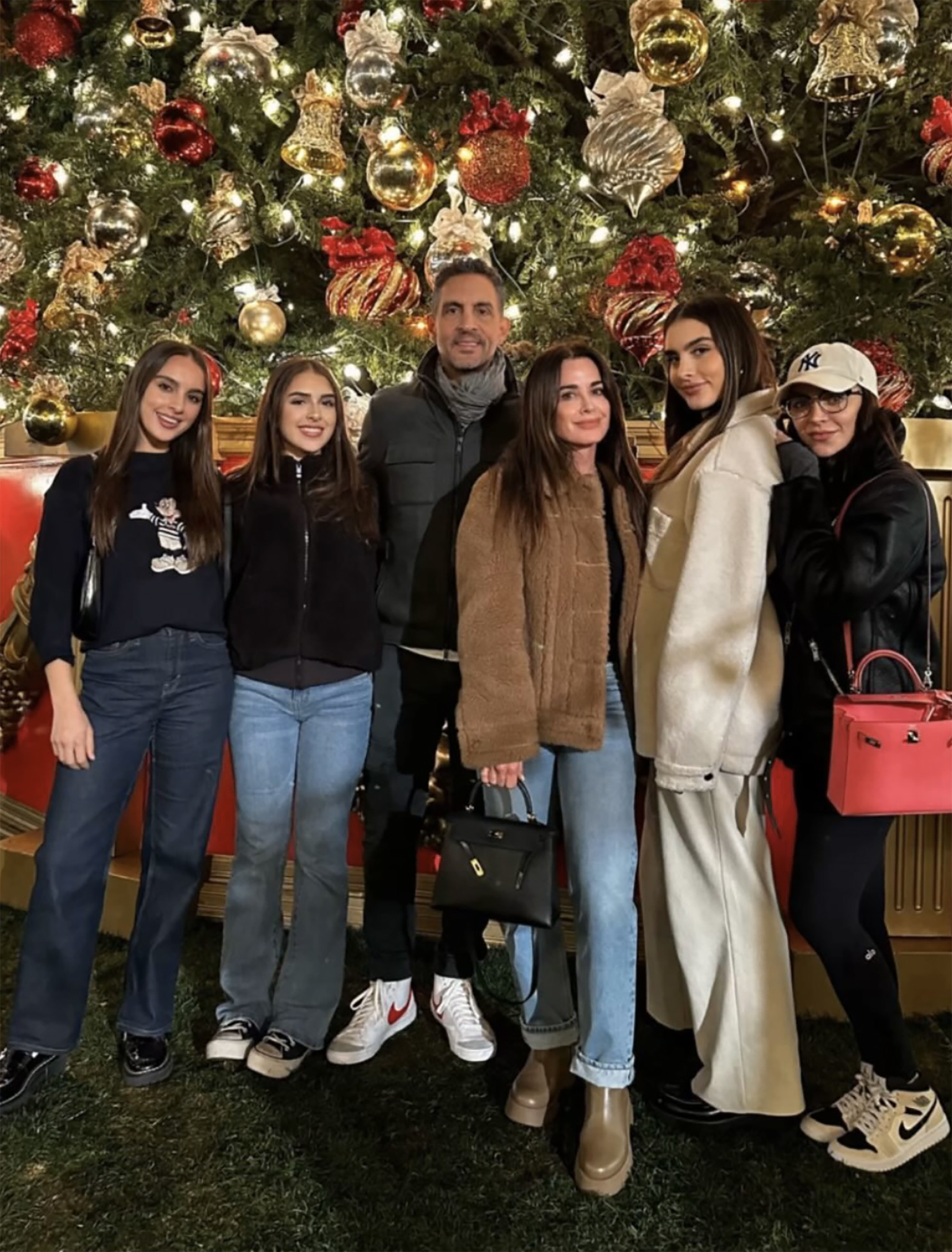 Mauricio Umansky and Kyle Richards posing with their four daughters in front of a Christmas tree.