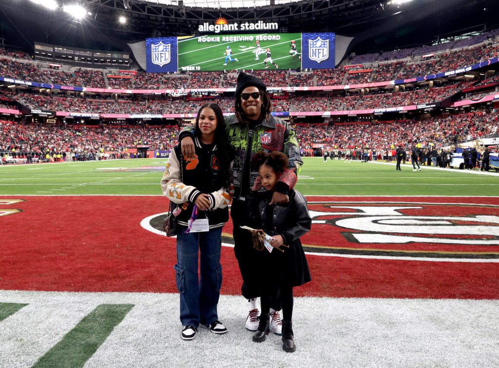 Jay-Z, Blue Ivy Carter, and Rumi Carter pose on the field at Super Bowl LVIII Pregame.