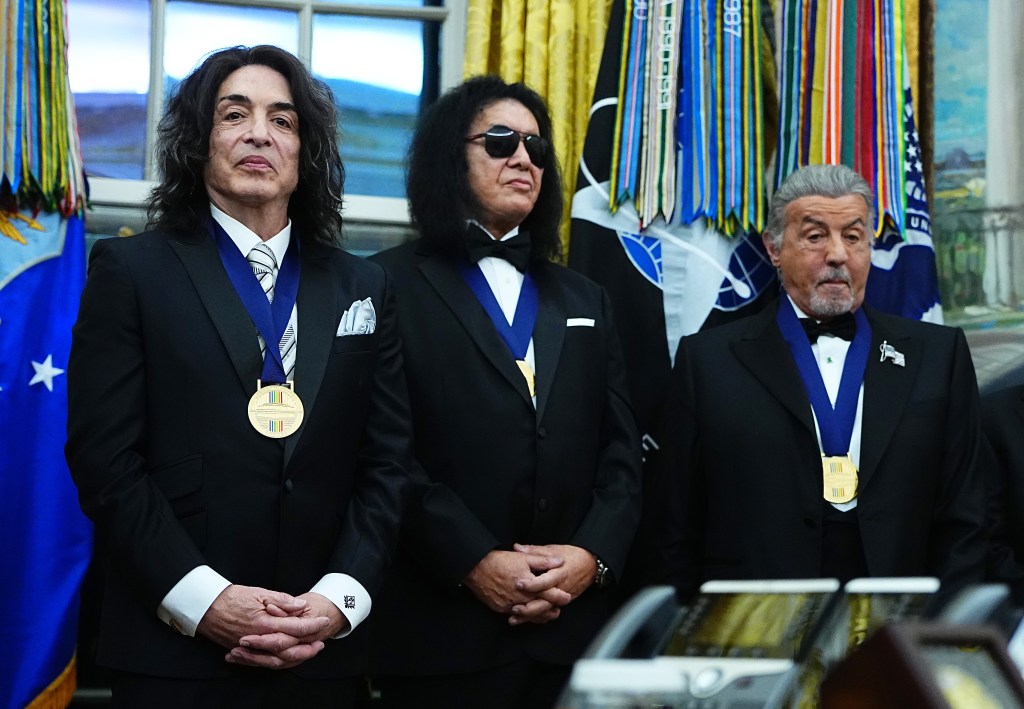 Paul Stanley, Gene Simmons, and Sylvester Stallone, wearing black suits and blue Kennedy Center Honor medals.