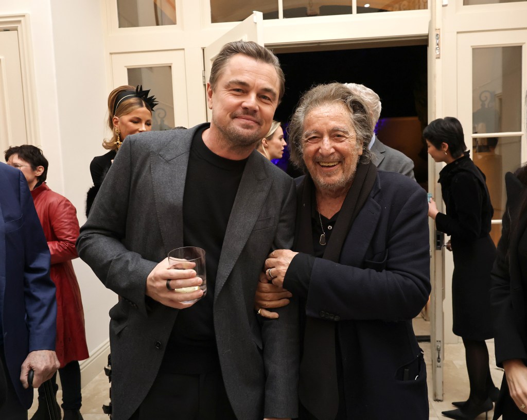 Leonardo DiCaprio and Al Pacino smiling at a celebration.