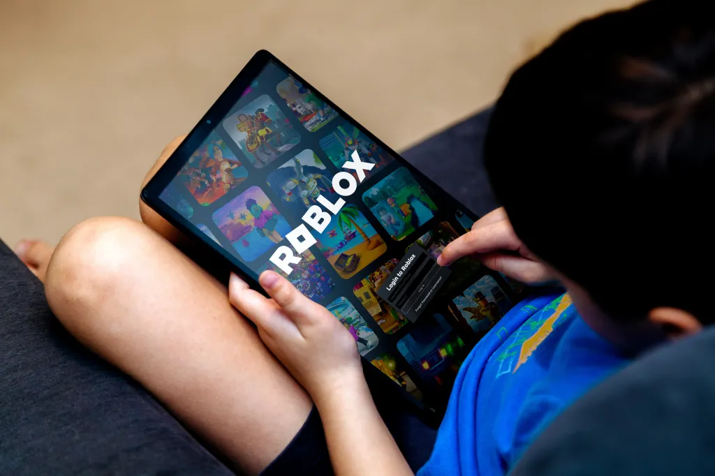 Young boy using a tablet to play the Roblox game.