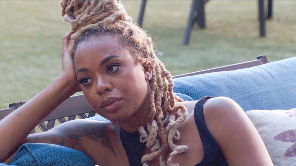 Mickey Lee sitting on a blue outdoor sofa.