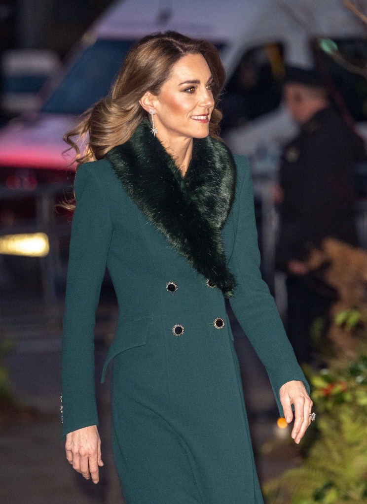 The Princess of Wales, Kate Middleton, wearing a dark green coat with a black faux fur collar and diamond star-shaped earrings.