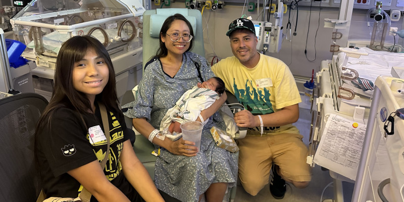 Suze Lopez, her husband, and daughter in a hospital room with their newborn baby.