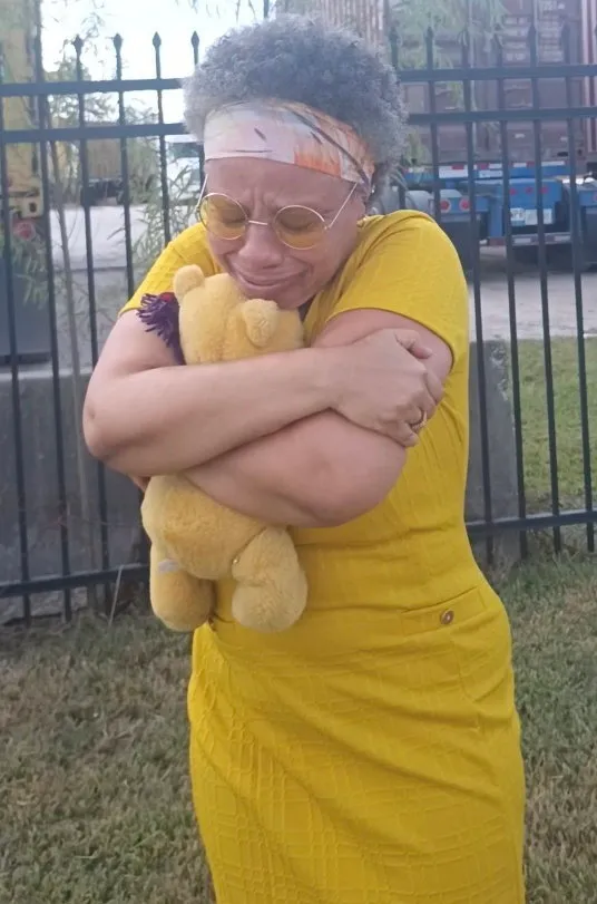 Lovetta Little-Smith crying while holding a teddy bear.