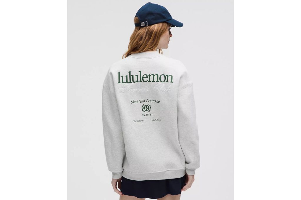 A woman in a grey sweatshirt, wearing a hat.