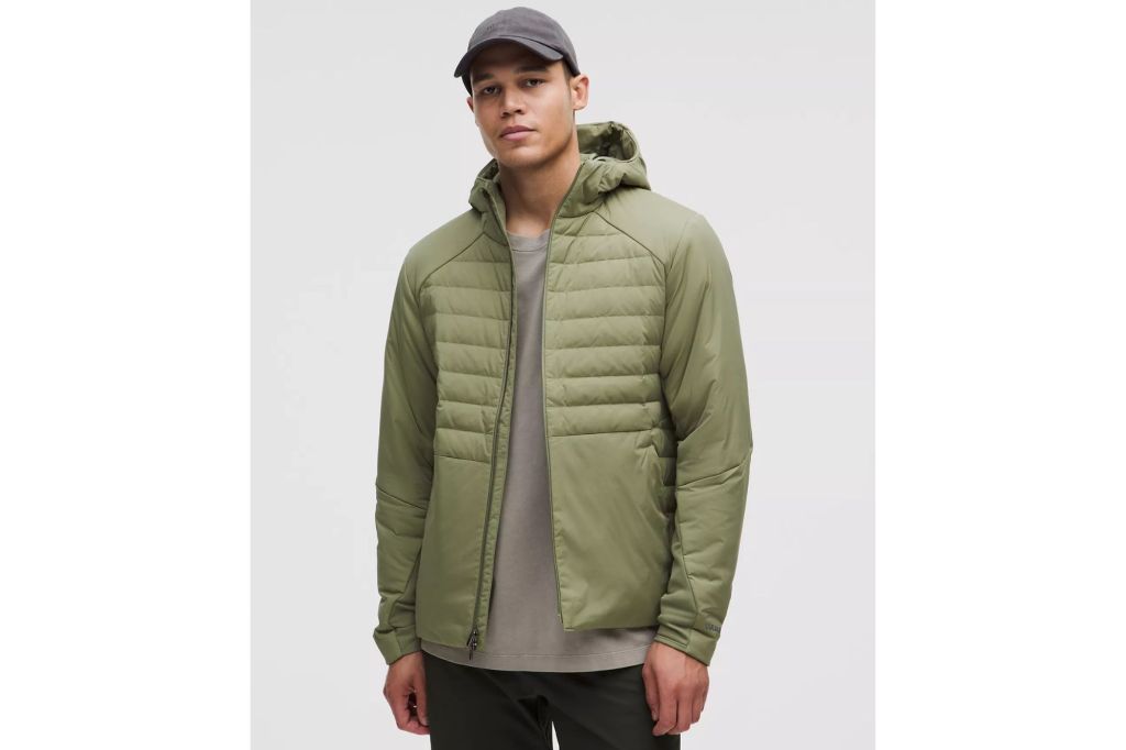 A man in a lightweight jacket, wearing a hat.