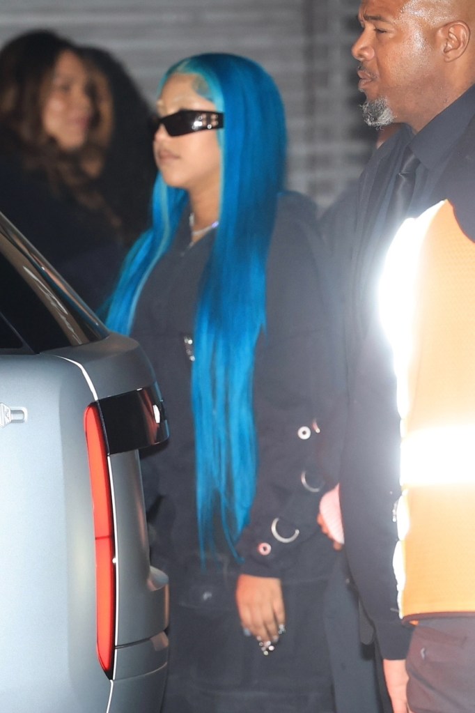 North West in an all-black outfit, sunglasses, and bright blue hair.