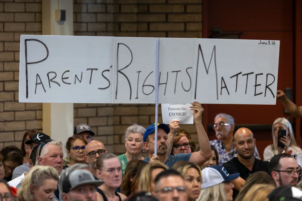 A man holds a sign reading