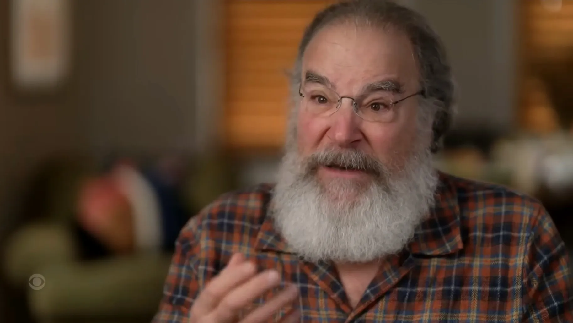 Mandy Patinkin wearing glasses and a plaid shirt.
