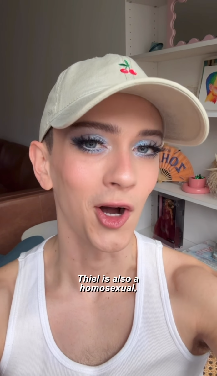 Matt Bernstein wearing a white tank top and a white baseball cap with cherry embroidery.