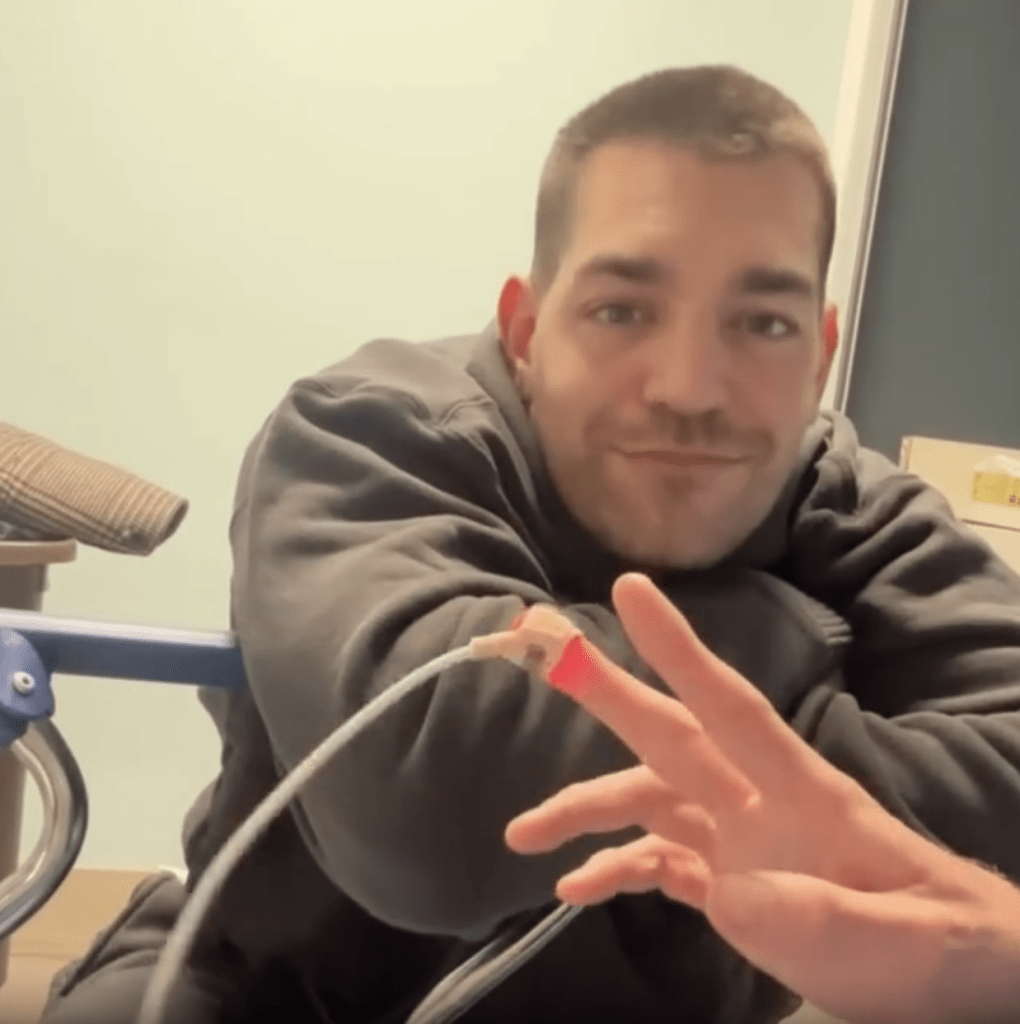 Matt Rogers sitting by Olender's hospital bed.