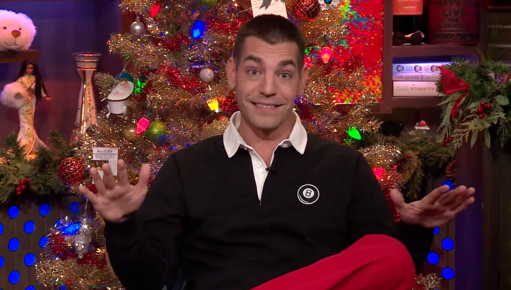 Matt Rogers with a Christmas tree behind him.