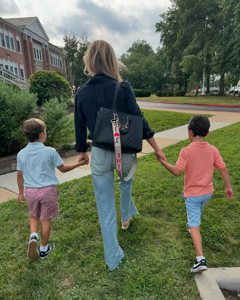 Meghan King holding hands with her two young sons.