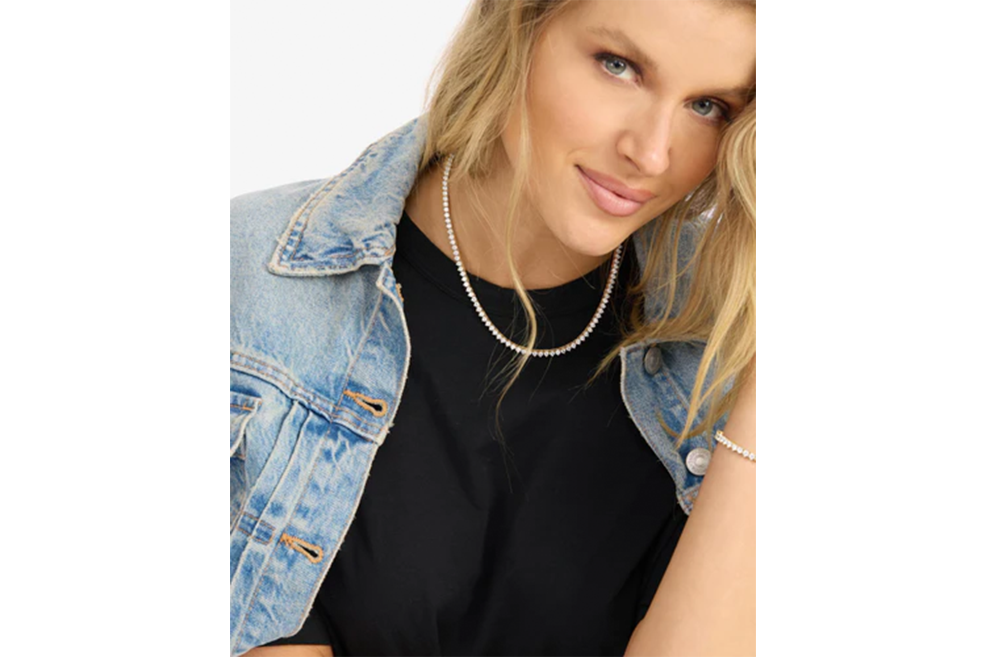 A woman wearing a diamond necklace and a diamond bracelet.