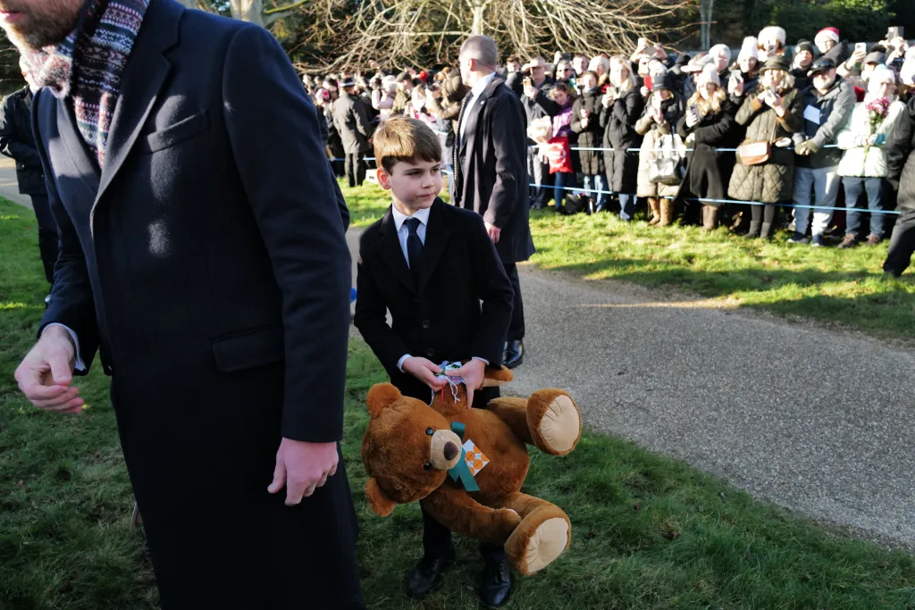 Prince Louis holding a teddy bear as he attends the annual Christmas service at Sandringham.