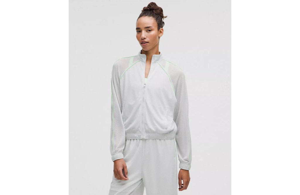 Woman wearing a light gray zip-up jacket and matching pants.