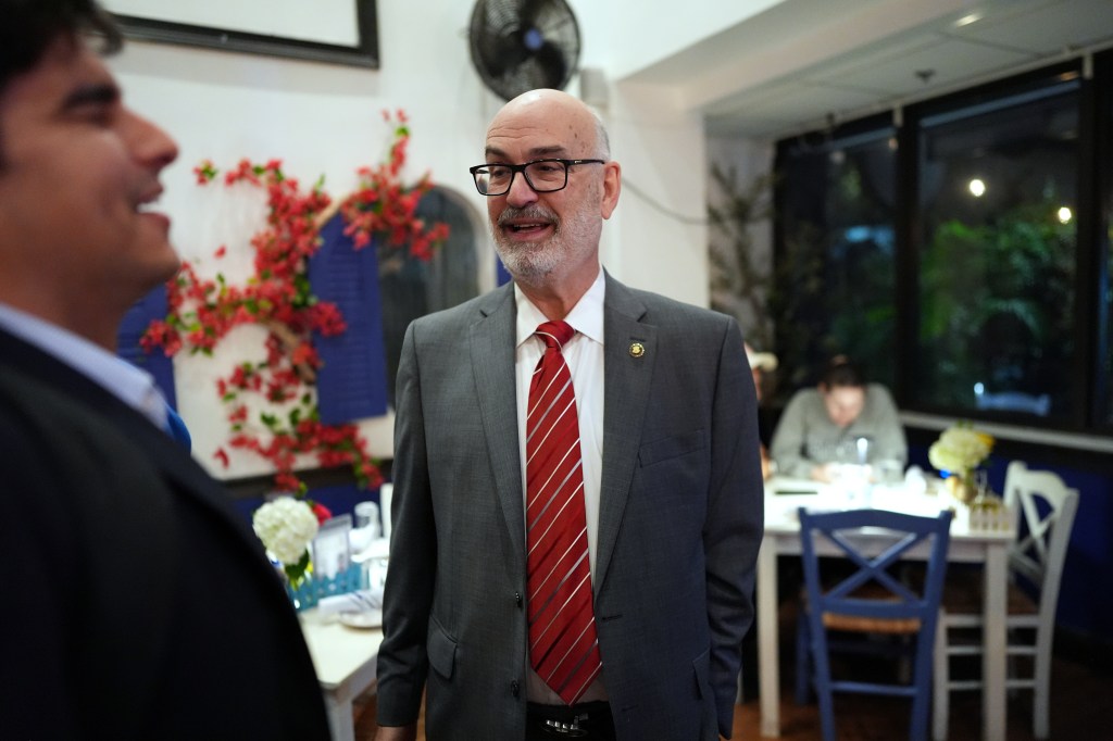 Emilio Gonzalez speaking with a journalist at a watch party.