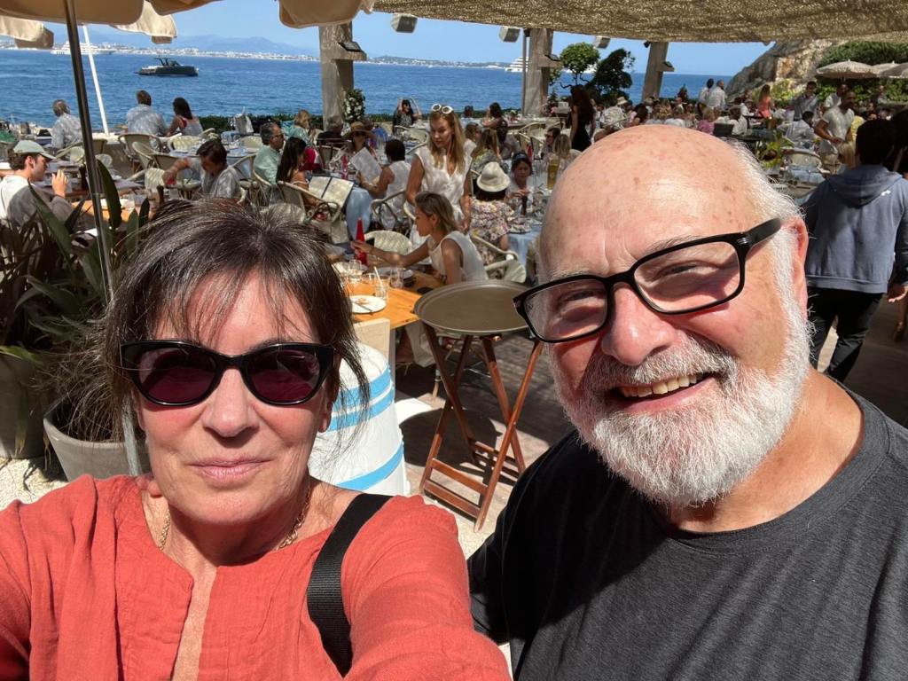 Michelle and Rob Reiner smiling at a restaurant by the sea.