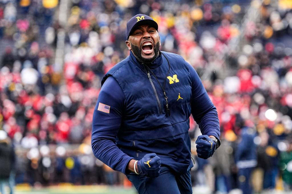 Michigan coach Sherrone Moore cheers during warmups.