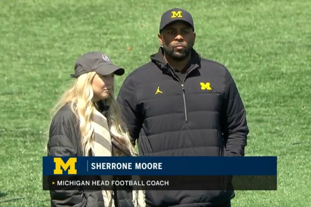 Michigan Head Football Coach Sherrone Moore and Paige Shiver on a field.