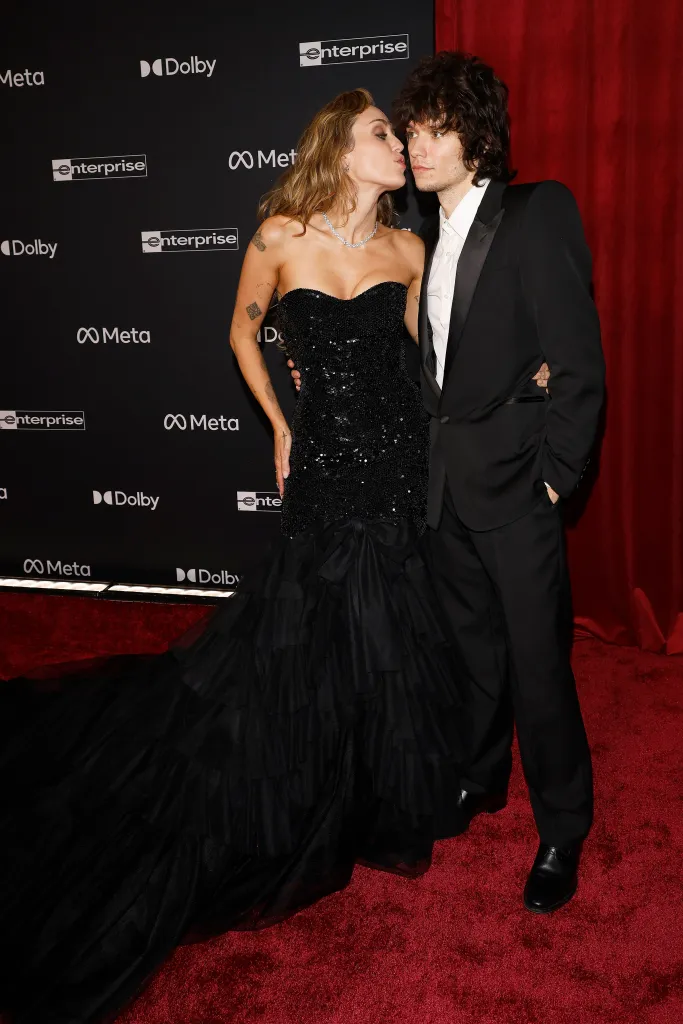 Miley Cyrus plants a kiss on Maxx Morando's cheek.