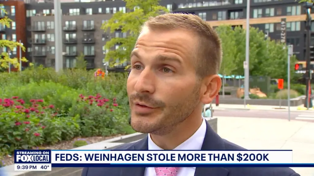 Man in a suit and pink tie being interviewed, with text overlay