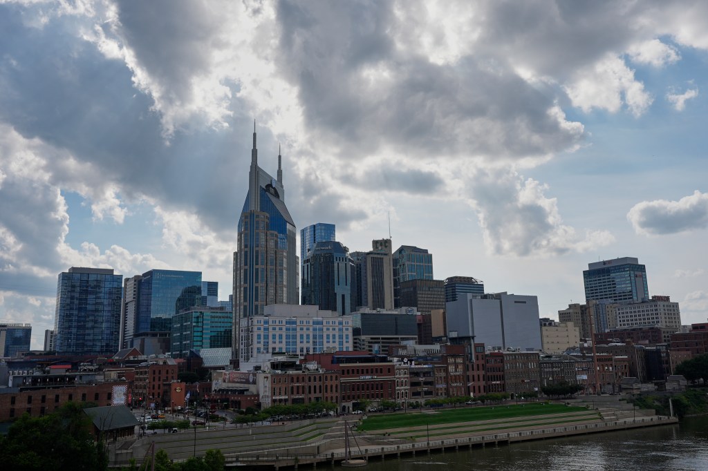 The Nashville, Tennessee skyline with the Batman Building prominent, under a partly cloudy sky.