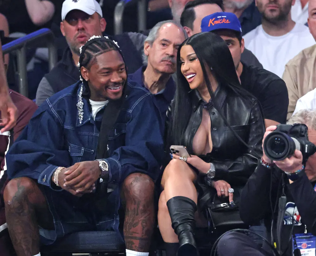Rapper Cardi B and NFL player Stefon Diggs sitting courtside during an NBA Playoff game.