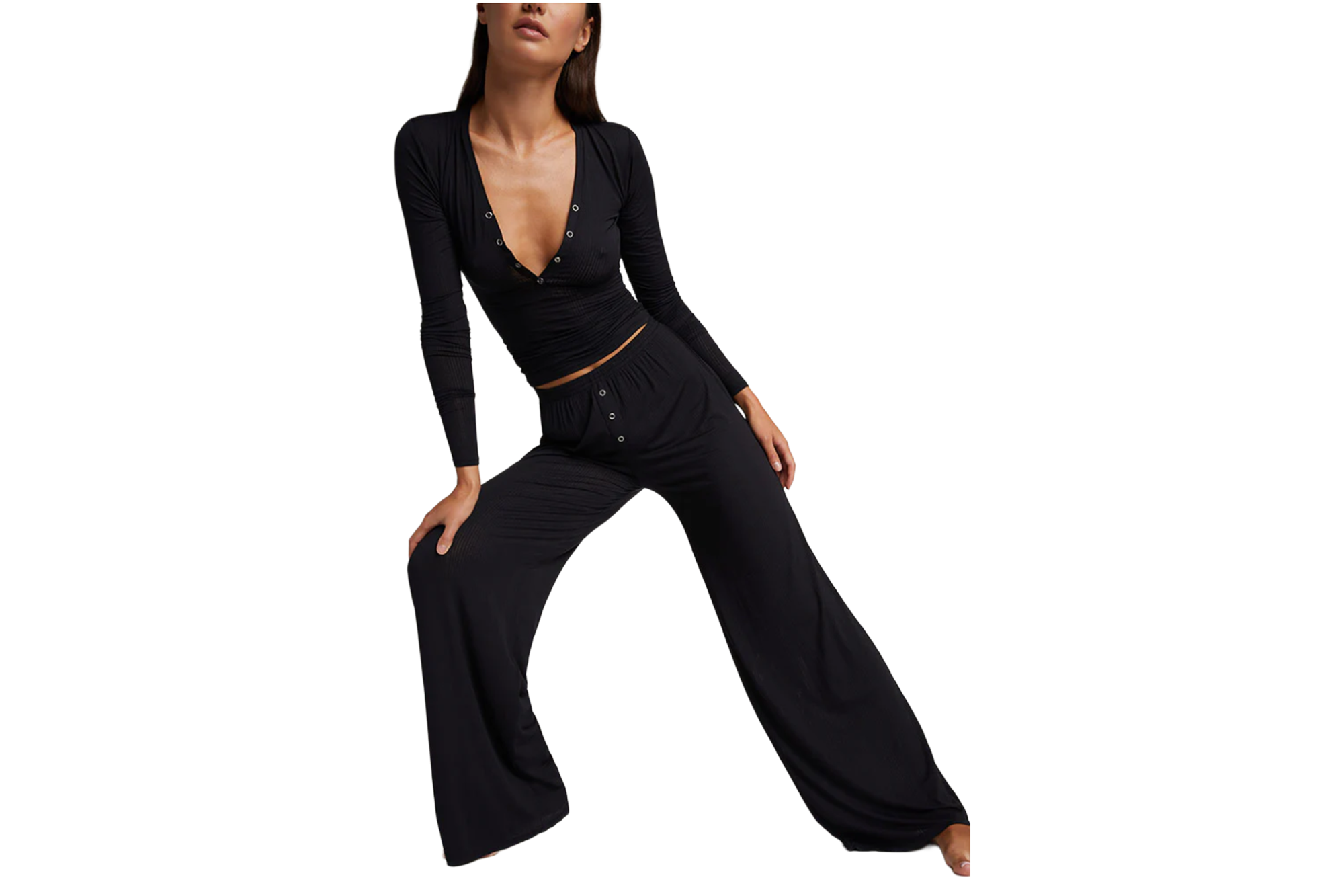 A woman in a black long-sleeve top with buttons and black wide-leg pants.