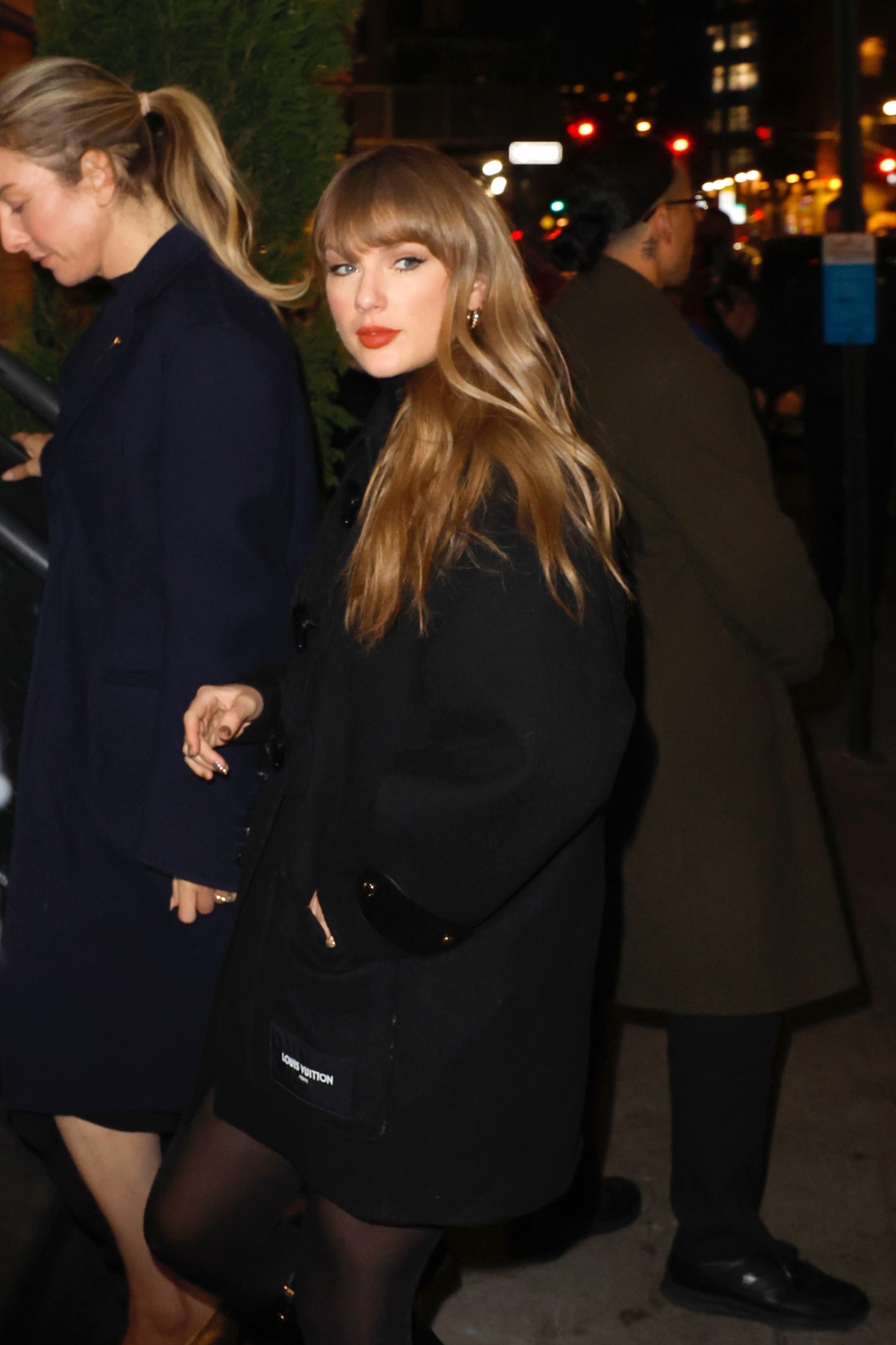 Taylor Swift in a black coat and tights at Chez Margaux with a friend.