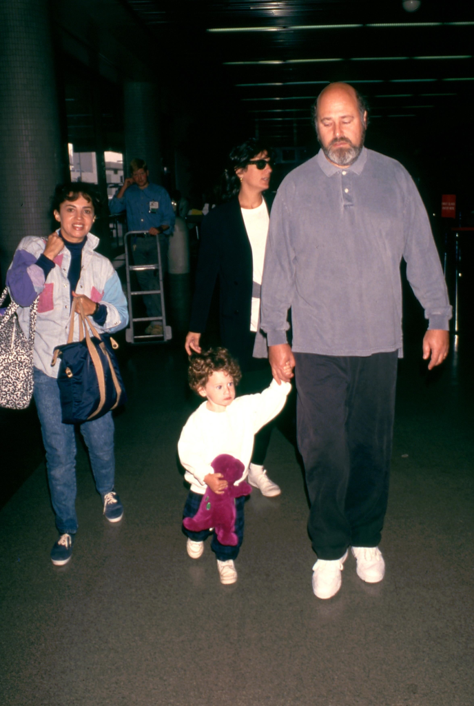 Rob Reiner and Michele Singer Reiner with a child holding a purple dinosaur toy.