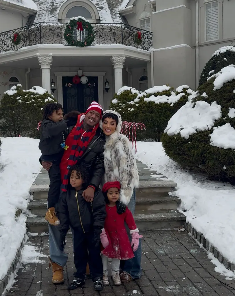 Nick Cannon and Abby De La Rosa with their three children in the snow.