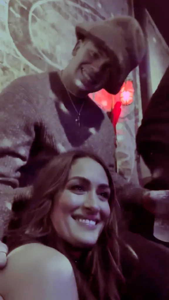 Nikki Bella smiling as Cooper DeJean looks over her shoulder.