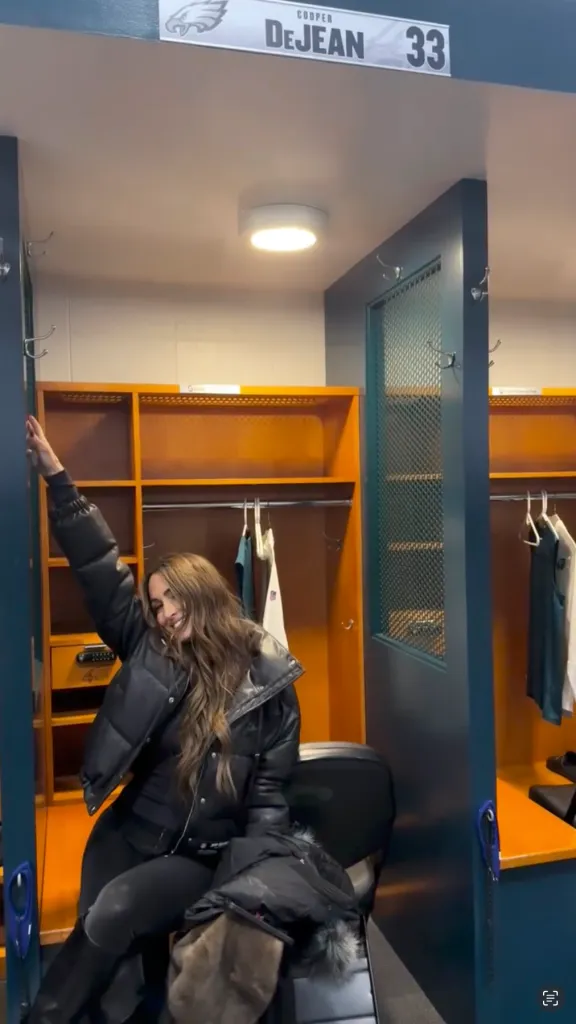 Nikki Bella posing playfully in an NFL locker room with a