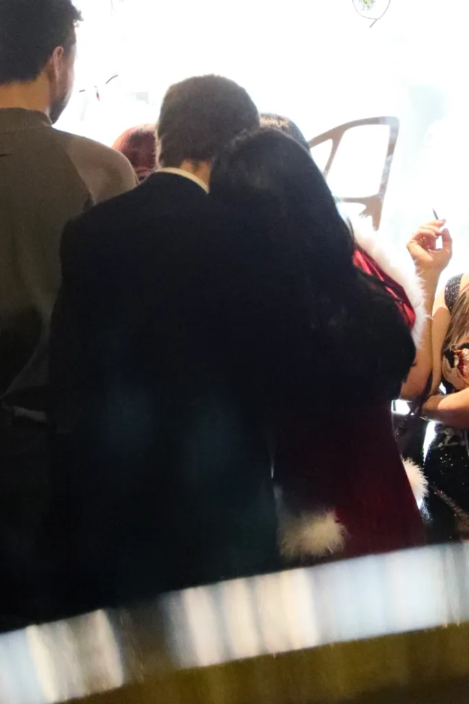 Jonah Freud in a black suit kissing Lily Allen in a red fur-trimmed dress.