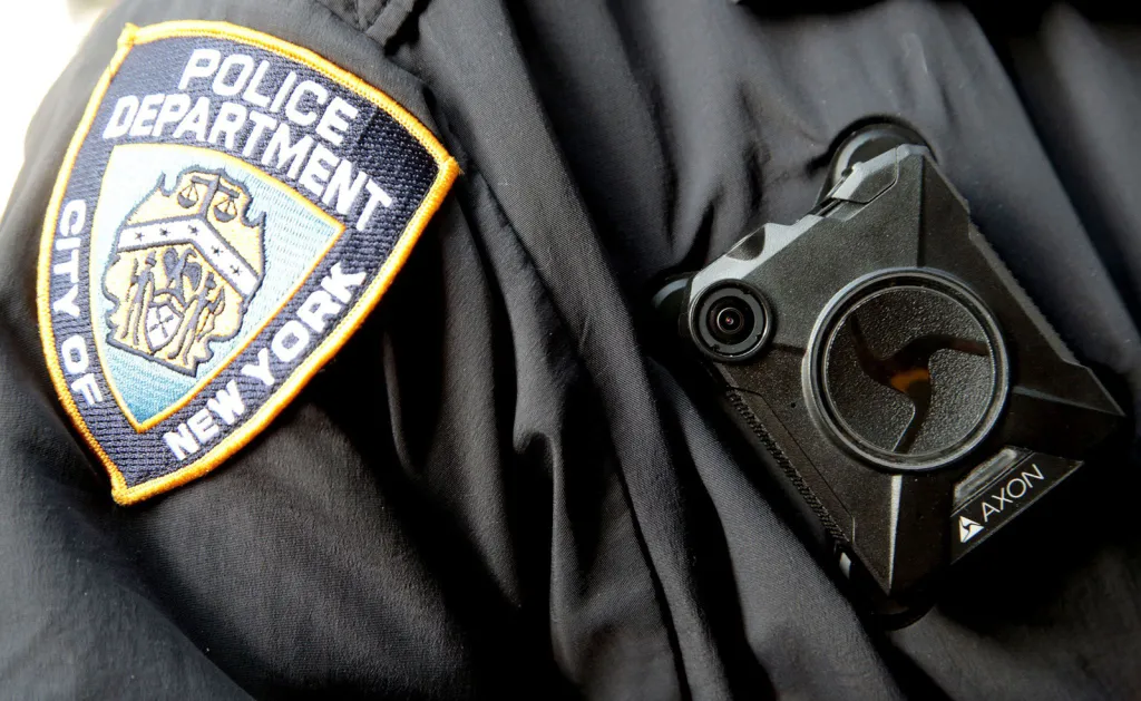 Close-up of a body camera attached to the uniform of an NYPD officer.
