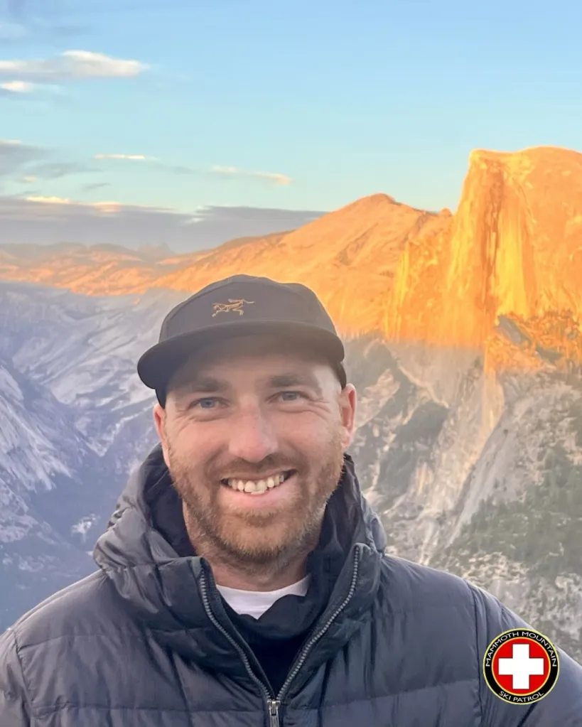 Cole Murphy, a ski patroller, smiling with a mountain range in the background.