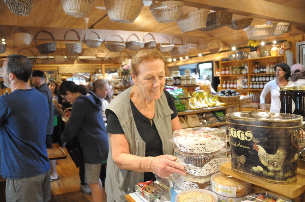 Carolyn Synder arranges products and veggies at the Round Swamp Farm store on 3 Mile Harbor Road in East Hampton.