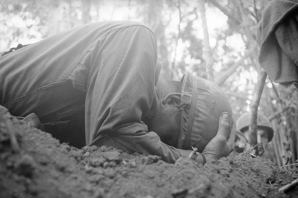 A photo Arnett took of a US paratrooper with the 173rd Airborne Brigade clutches his helmet as he takes cover during a North Vietnamese mortar attack in Vietnam, Nov. 21, 1967.