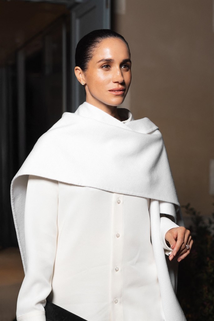 Meghan Markle in a white shirt and draped shawl.