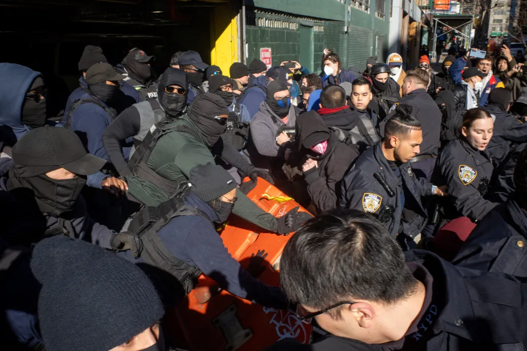 Police officers clashing with people gathered to prevent ICE officers from leaving for an immigration raid in New York City.