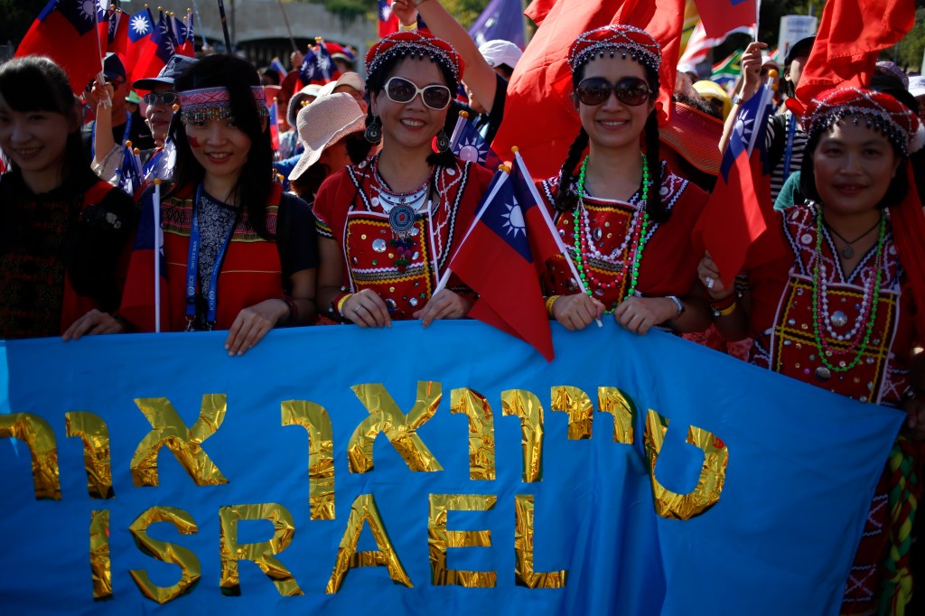 Taiwanese participants at a parade in Jerusalem holding a blue banner that reads