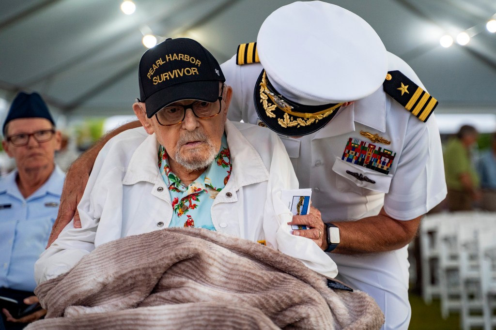 Pearl Harbor survivor Ira Schab talks to his son, retired Navy Cmdr. Karl Schab, at the 83rd Pearl Harbor Remembrance Day ceremony.