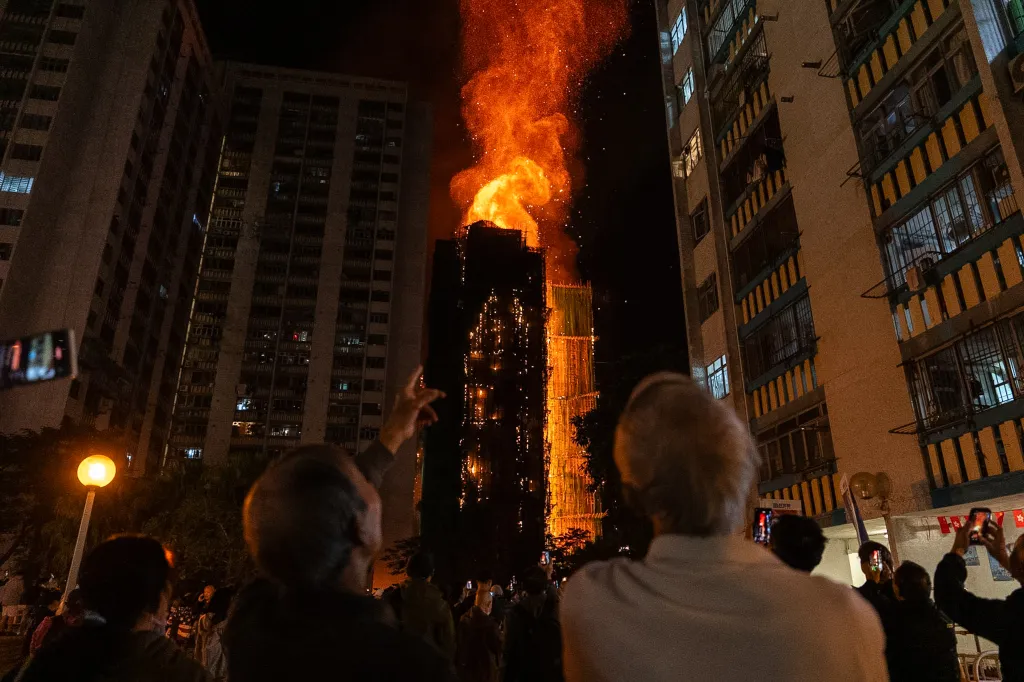 People watch as a residential building in Hong Kong is engulfed in flames.